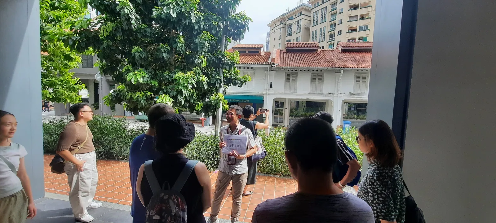 A Serai guide leading guests through a Singapore heritage shophouse alley